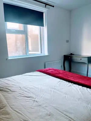 a bedroom with a white bed with a window at Bay Wind Apartment in Morecambe