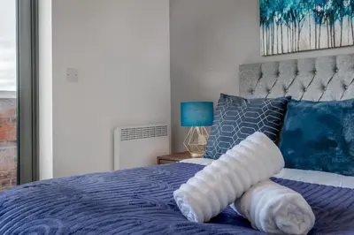 a bed with a pillow on top of it at Huge Long Stay Savings! City View Balcony Penthouse in Liverpool