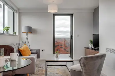 a living room with a couch and a table at Huge Long Stay Savings! City View Balcony Penthouse in Liverpool
