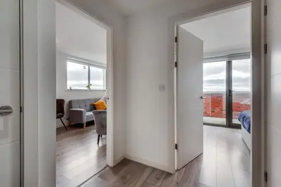 a bedroom with a door leading to a living room at Huge Long Stay Savings! City View Balcony Penthouse in Liverpool