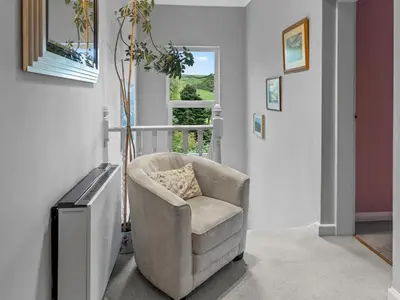 a living room with a chair and a window at Beautiful Detached Property Hot Tub Sauna - Pass the Keys in Lake Side