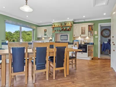 a kitchen with a wooden table and chairs at Beautiful Detached Property Hot Tub Sauna - Pass the Keys in Lake Side