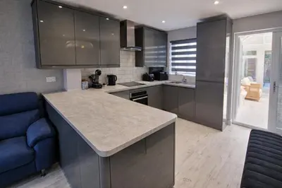 a kitchen with a counter and a blue couch at Liverpool House Near City Centre in Liverpool