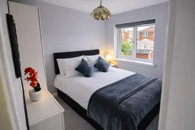 a bedroom with a bed with blue pillows and a window at Liverpool House Near City Centre in Liverpool