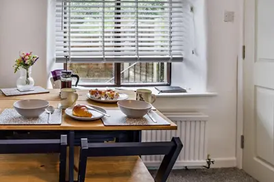 a table with two plates of food on it in front of a window at 2 Bed in Ulverston oc-q29885 in Ulverston