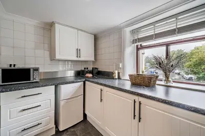 a kitchen with white cabinets and a window at 2 Bed in Ulverston oc-q29885 in Ulverston