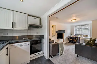 a kitchen with white cabinets and a living room at 2 Bed in Ulverston oc-q29885 in Ulverston