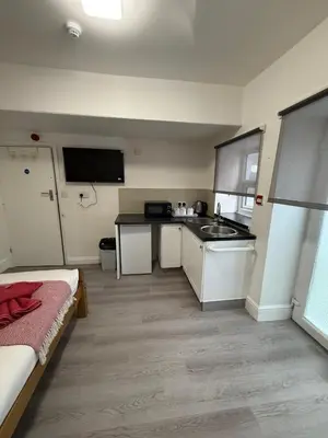 a small kitchen with a sink and a bed in a room at Suli House-Families and Couples only- 3 minutes' walk to the seafront in Blackpool