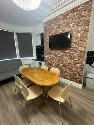 a dining room with a wooden table and chairs at Suli House-Families and Couples only- 3 minutes' walk to the seafront in Blackpool