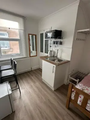a small kitchen with a sink and a microwave at Suli House-Families and Couples only- 3 minutes' walk to the seafront in Blackpool