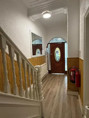 a hallway with a staircase and a wooden door at Suli House-Families and Couples only- 3 minutes' walk to the seafront in Blackpool