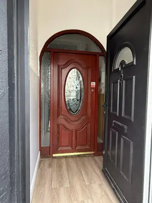 a red door in a hallway with a window at Suli House-Families and Couples only- 3 minutes' walk to the seafront in Blackpool
