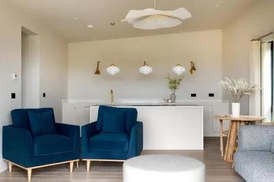 a kitchen with two blue chairs and a counter at The Lookout in Preston