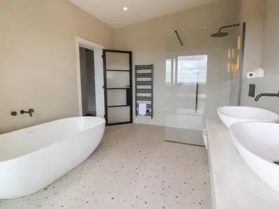 a white bathroom with two sinks and a tub and shower at The Lookout in Preston