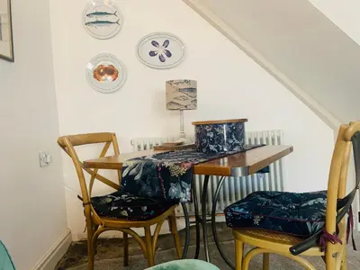 a dining room with a table and two chairs at Cockle Bay Cottage in Morecambe