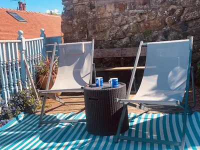two chairs and a table on a patio at Cockle Bay Cottage in Morecambe