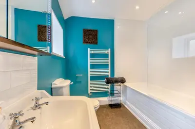 a bathroom with a white tub and a blue wall at 3 Bed in Newton In Cartmel oc-a29796 in High Newton