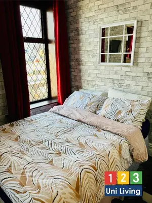 a large bed in a room with a window at Leatham Park Hotel Blackpool in Blackpool
