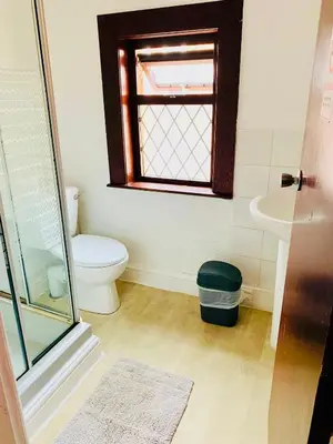 a bathroom with a toilet and a sink and a window at Leatham Park Hotel Blackpool in Blackpool