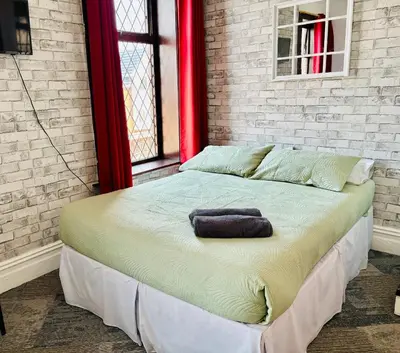 a large bed in a room with a brick wall at Leatham Park Hotel Blackpool in Blackpool
