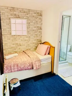 a bedroom with a bed and a brick wall at Leatham Park Hotel Blackpool in Blackpool