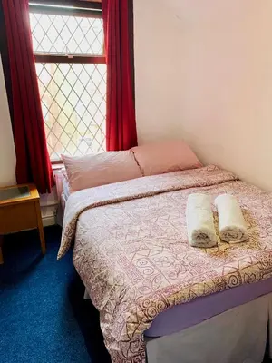 a bedroom with a bed with two pillows and a window at Leatham Park Hotel Blackpool in Blackpool