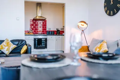 a living room with a table with plates on it at Private garden maisonette near city centre! Walking distance from Anfield in Liverpool