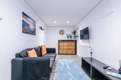 a living room with a couch and a tv at Private garden maisonette near city centre! Walking distance from Anfield in Liverpool