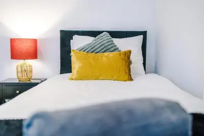 a bedroom with a white bed with a yellow pillow at Private garden maisonette near city centre! Walking distance from Anfield in Liverpool