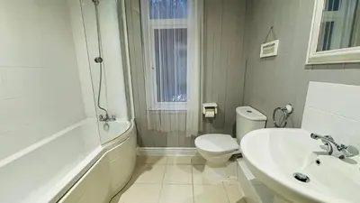 a white bathroom with a toilet and a sink at Le Papillon Hotel Blackpool in Blackpool