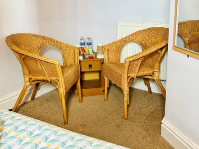 two wicker chairs and a side table in a room at Le Papillon Hotel Blackpool in Blackpool