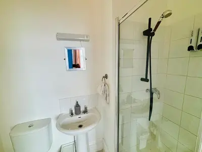 a bathroom with a shower and a toilet and a sink at Le Papillon Hotel Blackpool in Blackpool