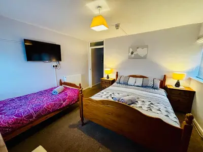 a bedroom with a bed and a flat screen tv at Le Papillon Hotel Blackpool in Blackpool