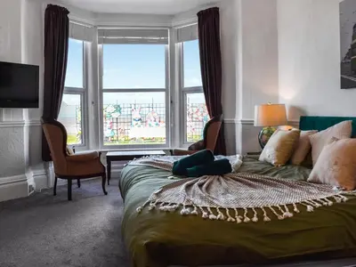 a bedroom with a bed and a large window at Drumford in Blackpool