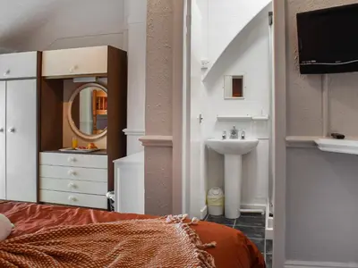 a bedroom with a sink and a mirror at Drumford in Blackpool