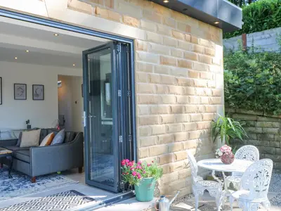a patio with a glass door and a table and chairs at Priestleys Retreat in Blackburn