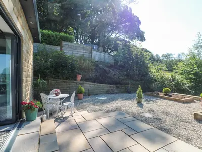 a patio with a table and chairs in a yard at Priestleys Retreat in Blackburn