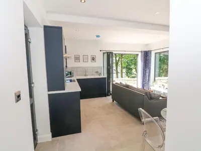a living room with a couch and a kitchen at Priestleys Retreat in Blackburn