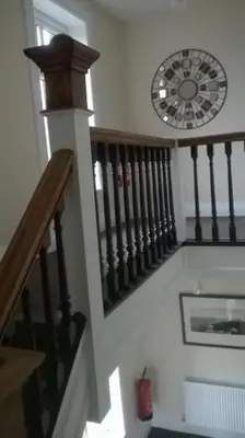 a staircase with a clock on the wall next to a stair case at The Rafters Bank House Stunning Apartment in Millom