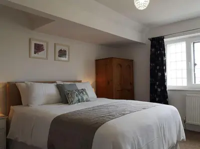 a bedroom with a large bed and a window at The Rafters Bank House Stunning Apartment in Millom