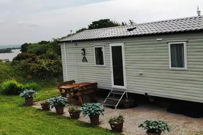 a tiny house with a picnic table and a bench at Sea breeze, modern, cosy holiday home in Haverigg