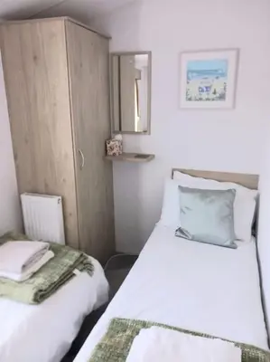 a small room with two beds and a mirror at Sea breeze, modern, cosy holiday home in Haverigg