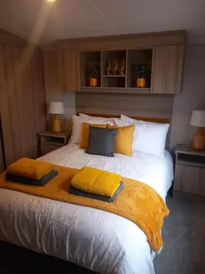 a bedroom with a large bed with pillows on it at Nadia's Lodge Smart TV & Wi-Fi in Haverigg