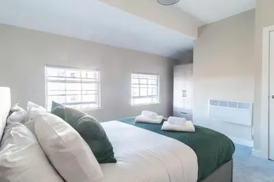 a bedroom with a large bed with green and white pillows at Charming 1 Bedroom Apartment in Central Liverpool in Liverpool