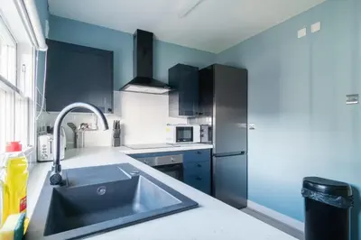 a kitchen with a sink and a stainless steel refrigerator at Charming 1 Bedroom Apartment in Central Liverpool in Liverpool