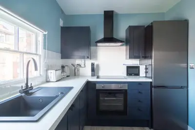a kitchen with a sink and a refrigerator at Charming 1 Bedroom Apartment in Central Liverpool in Liverpool