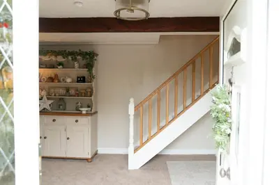 a staircase in a home with a white stair case at Peacock Room at Field View Cottage in Eccleston