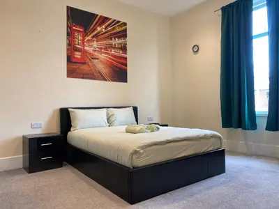 a bedroom with a bed with a picture on the wall at Springfield Guesthouse in Blackburn
