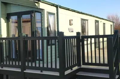 a screened porch with a black fence at Lagooncombe modern and cosy holiday home in Haverigg