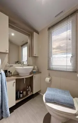 a bathroom with a toilet and a sink at Lagooncombe modern and cosy holiday home in Haverigg